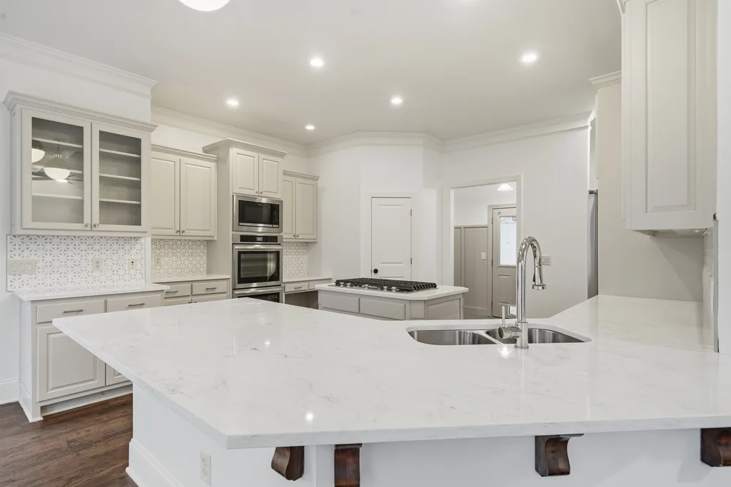 White kitchen with a marble island at 2755 Aldrich Drive, Cumming