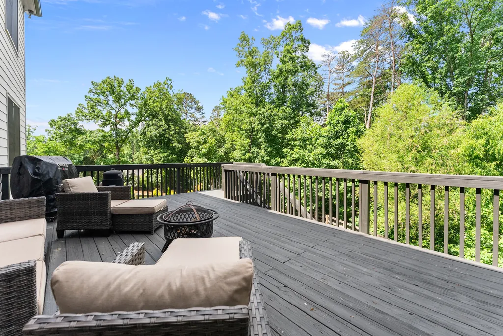 Back deck with outdoor seating and a fire pit at 6625 Baywood Run, Cumming