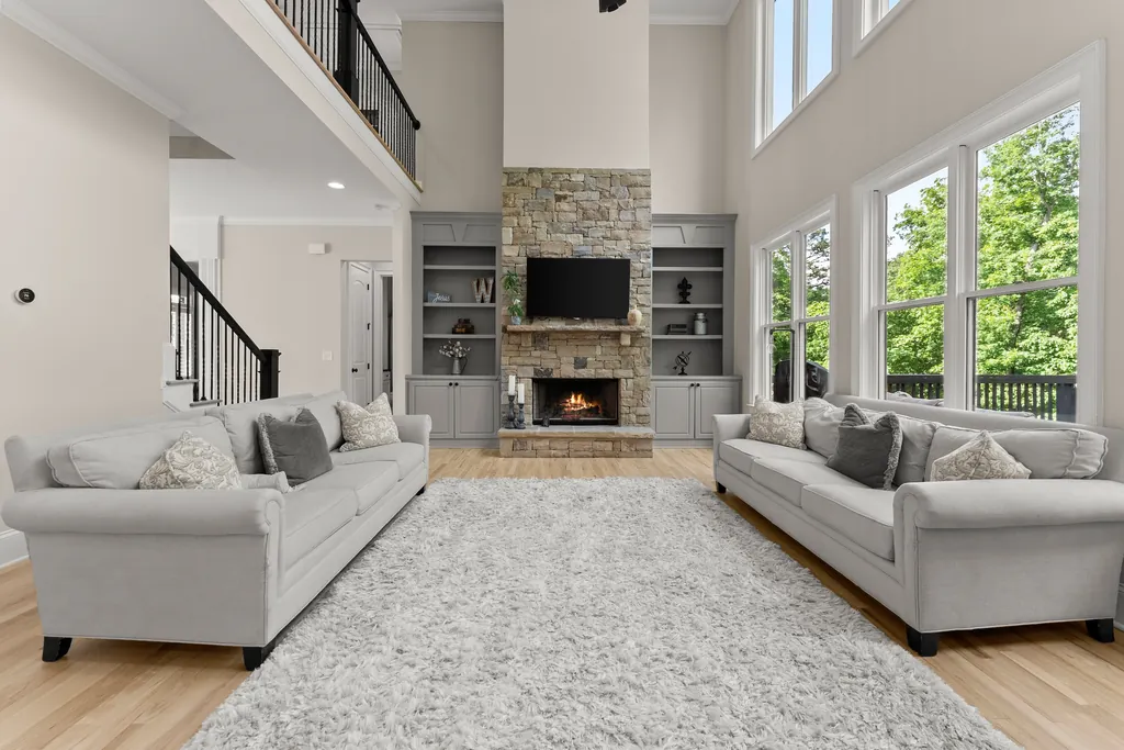 Two-story great room with a stone fireplace at 6625 Baywood Run, Cumming