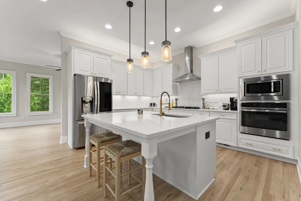 Renovated white kitchen with an island and pendant lights at 6625 Baywood Run