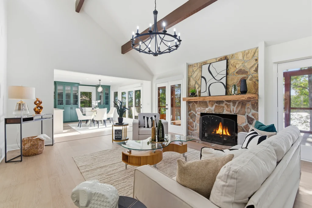 Vaulted great room with a stone fireplace and beamed ceiling at 5685 Cherokee Trace