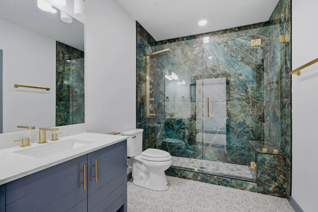 Bathroom with a green marble shower and gold fixtures at 7605 Poppy Mill Lane